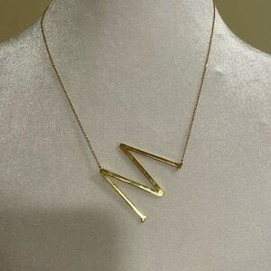 Gold toned sideways initial M necklace​​​​
